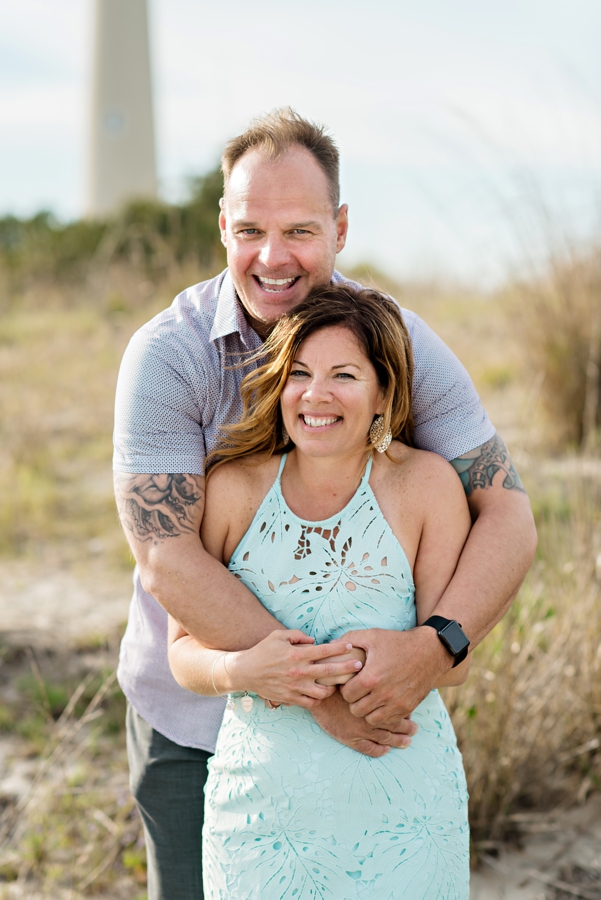 An engaged couple hold each other on the beach in cape may, nj.